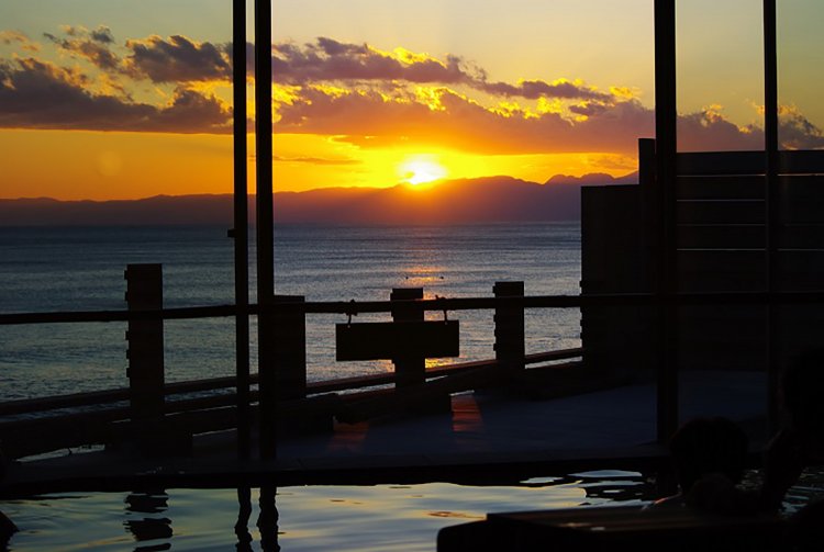 夕焼けに染まる海。自分の体も夕日に照らされ黄金色に。