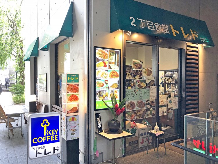 料理の写真やメニューが多数貼られた窓からカウンターと厨房が垣間見える。