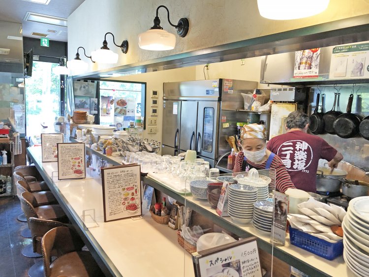 オープンキッチンのカウンター席。奥にはグループで座れるテーブル席もある。