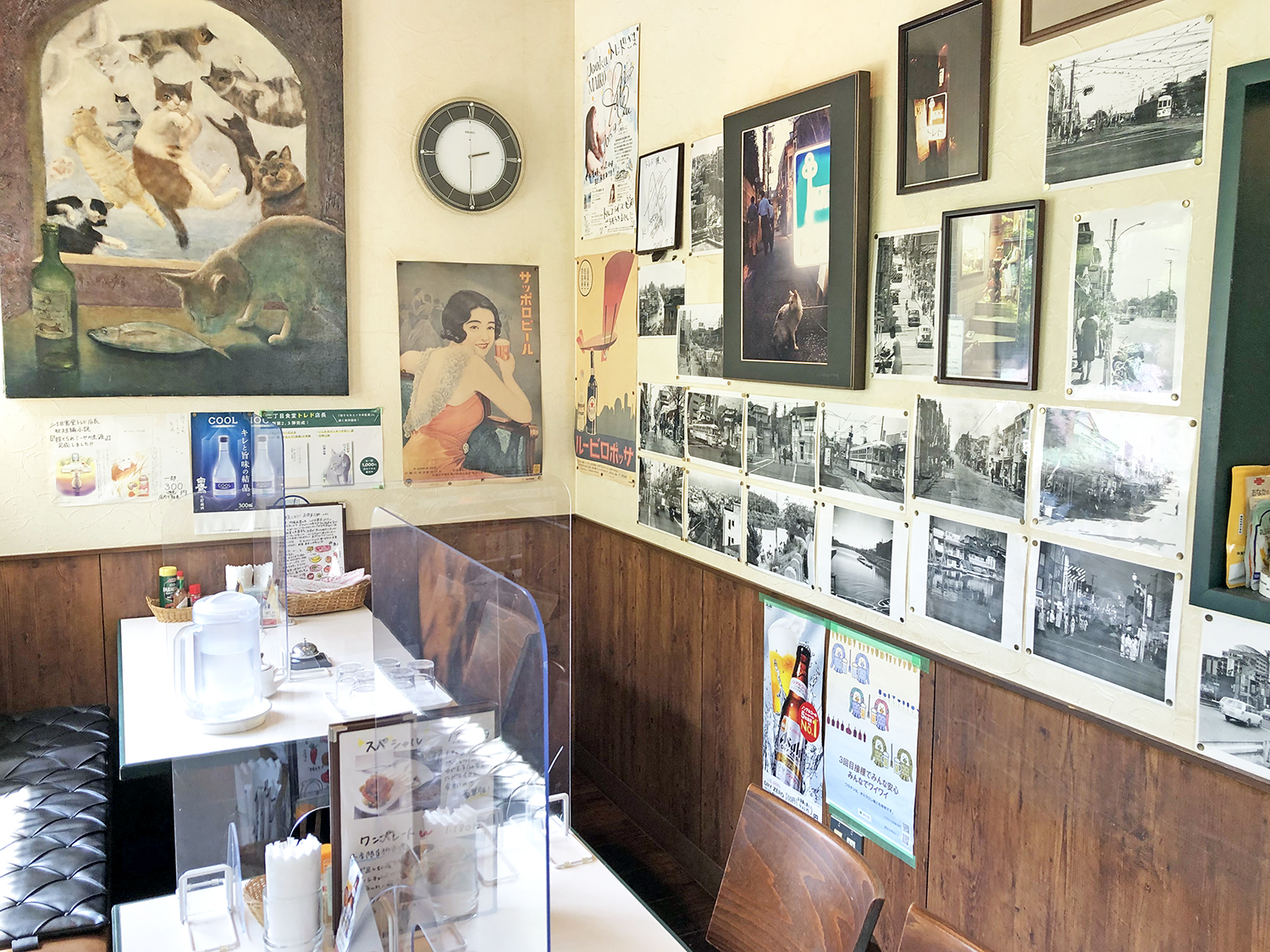 テーブル席の壁には神楽坂とお店の歴史を物語る写真の数々が飾られている。