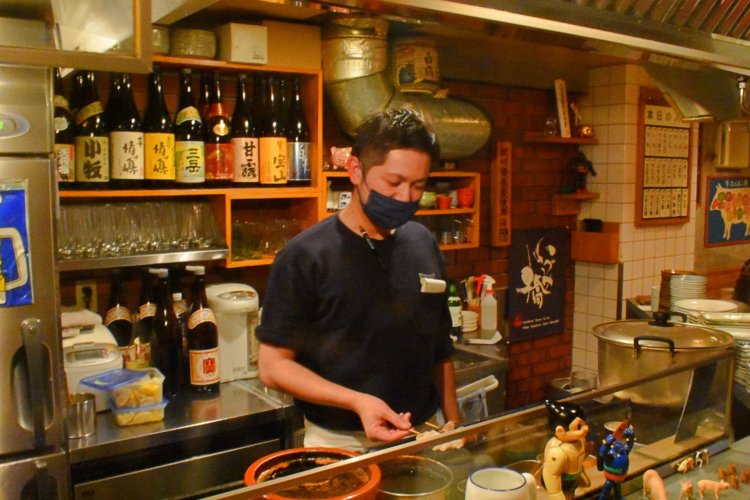 店長の小川裕之さん。真剣な表情で、一串一串焼き上げていく。