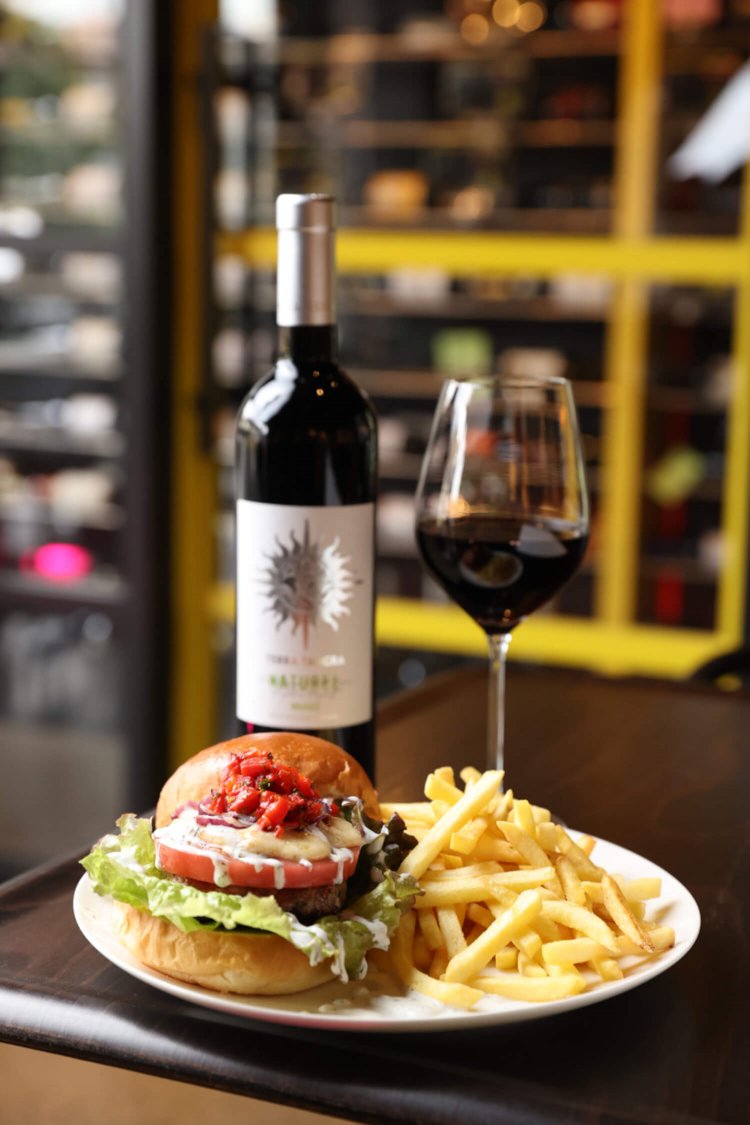 東欧テイストのバルカンバーガー 1078円（ポテトは別売り）、グラスワイン 528円～。