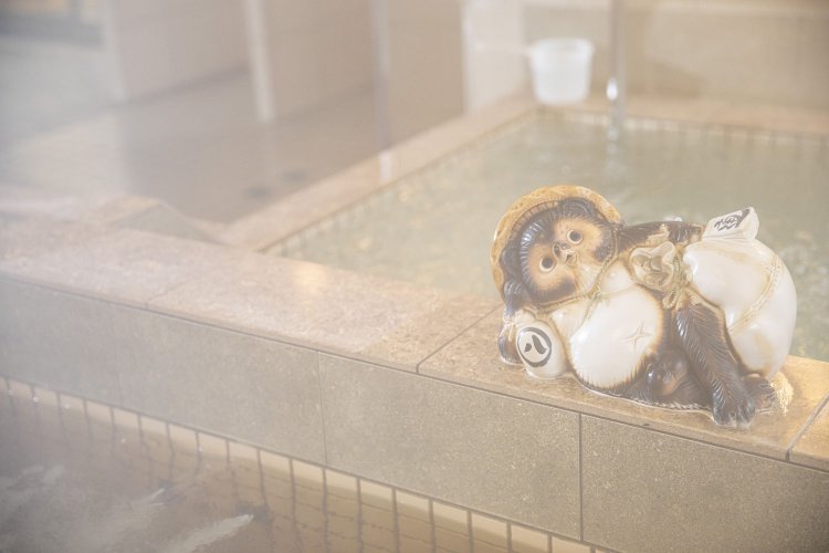 “他を抜く”の縁起担ぎで2代目が好んだタヌキが１階浴室の湯船で気持ちよさそうに寝そべっている。