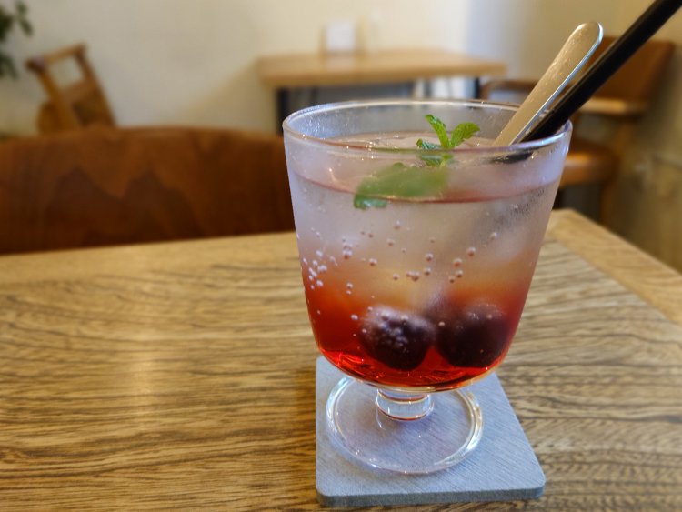 季節の酢ソーダ780円。アメリカンチェリーの実を漬けた果実酢のソーダ割りは、甘酸っぱく爽やか。