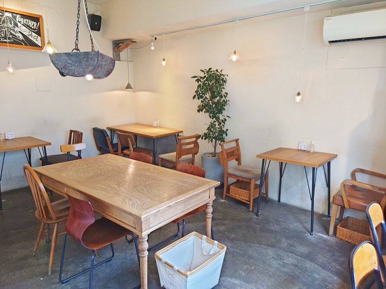 3階のカフェスペース。2人掛けを中心にテーブル席がほどよい感覚で並ぶ。