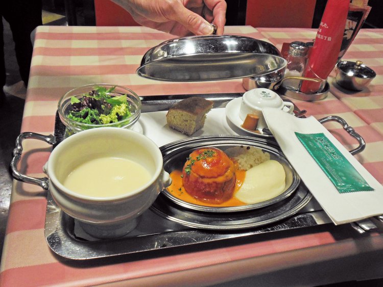 銀のトレイで運ばれてくるワンプレート料理。目の前でプレートの蓋が開き、丸ごとトマトがお目見え！