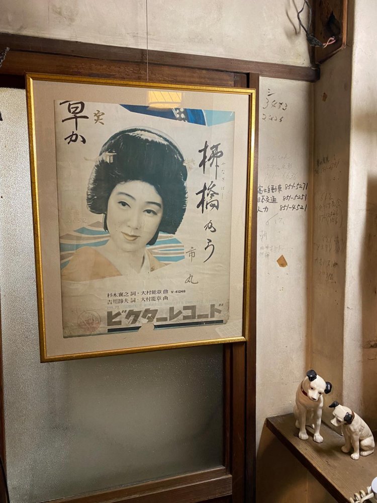 市丸姐さんのレコードジャケット。右には市丸姐さん直筆のタクシー会社の電話番号と、ビクターのトレードマークの犬の置き物。