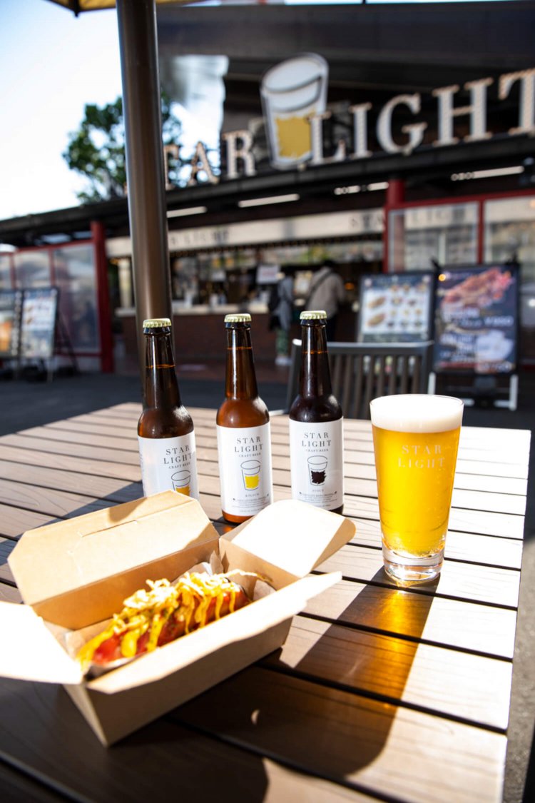 レストラン『スターライト』でオリジナルのクラフトビール 750円（全3種）と太くて ジューシーなスターライトウィナードッグ 800円をテイクアウト。テラス席が最高！