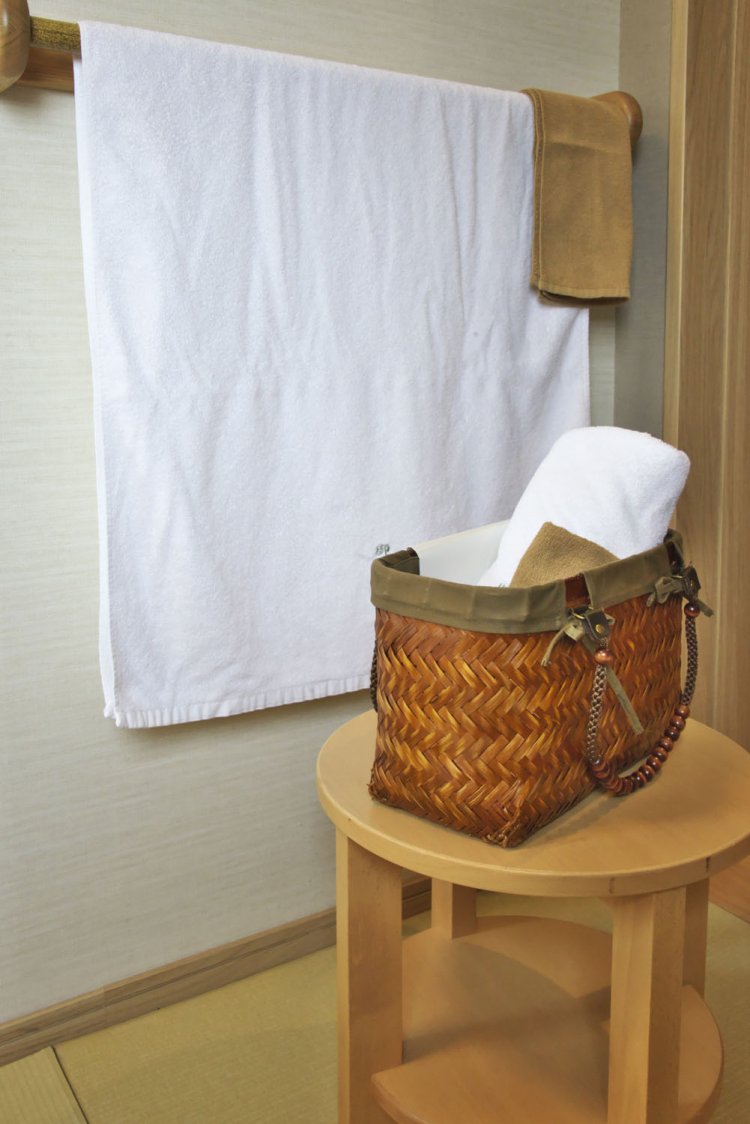 部屋にはバスタオルを広げて干せるタオル掛けと温泉行きの湯かご。