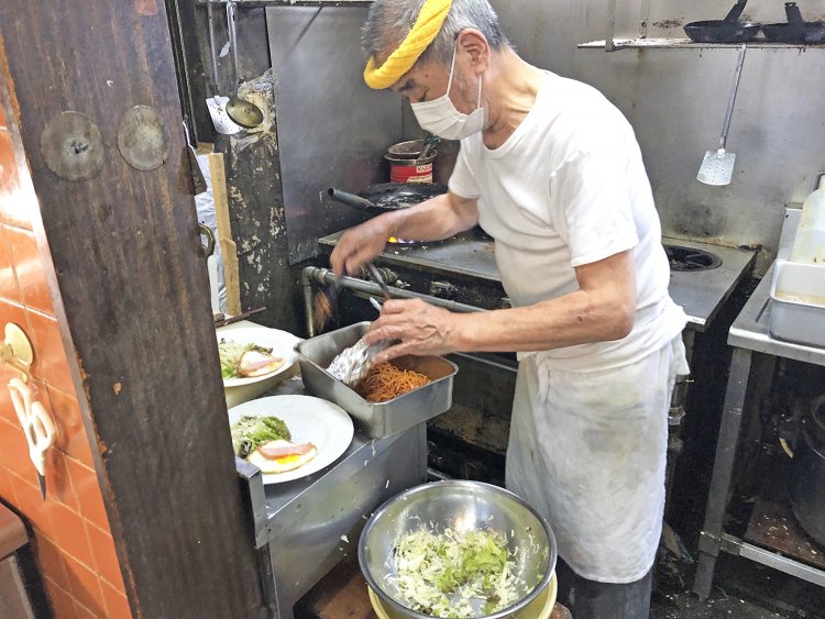 一瞬も動きを止めず調理中。