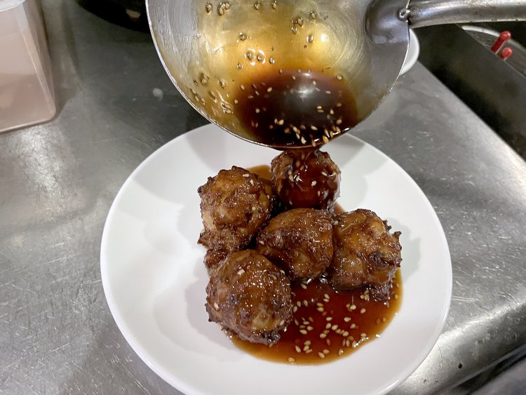 揚げた肉団子を中華鍋で炒めて甘酢あんにからめてできあがり。とろ〜りとしたツヤツヤのあんが肉団子にかかっておいしそう！