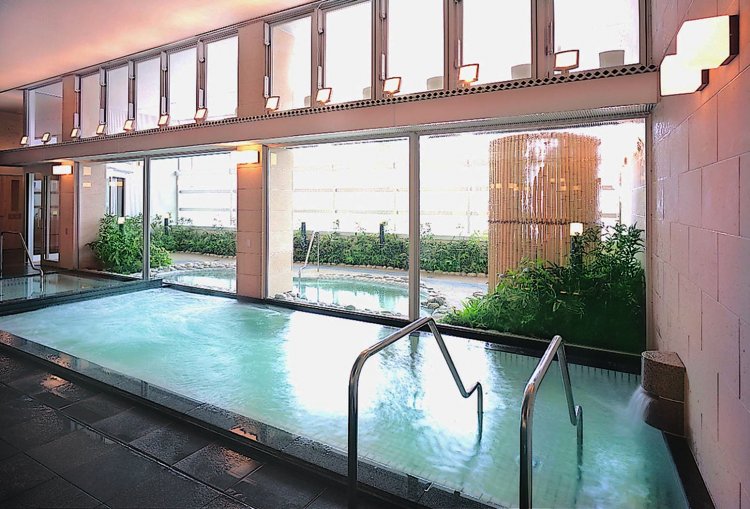 露天エリアを望む大きなガラス窓が明るい雰囲気を演出するトルマリン風呂。
