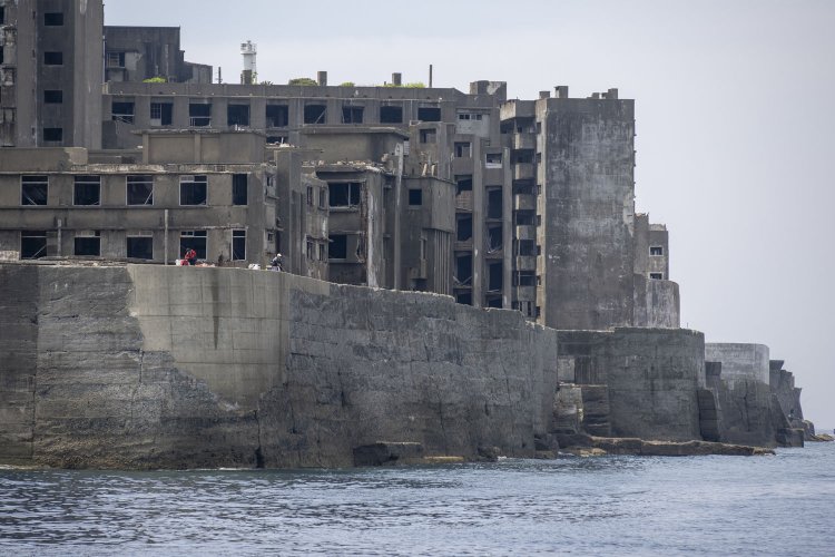 西側の住居棟を望遠レンズで圧縮すると、様々な形状のRC造アパートがギュッと凝縮して写る。建築年代が異なる建物群が林立する姿は壮観である。高い城壁のような護岸に囲まれて、城郭都市の廃墟にも見えてくる。