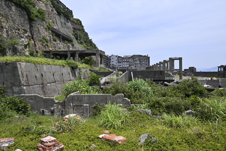 上陸した！　感無量である。第1見学広場に移動すると北側には貯炭場施設の遺構がゴロゴロ。背後が学校だ。橋脚みたいなものは貯炭ベルトコンベヤー支柱。ここから石炭運搬船に石炭を積み込んでいた。