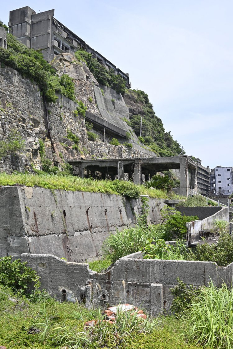 北側。手前のコンクリート遺構は「炭車修理工場」。その奥は「浮選機室」で、石炭を選別するときに使用する設備の機械室かと思われる。崖上にそそり立つのは3号棟。
