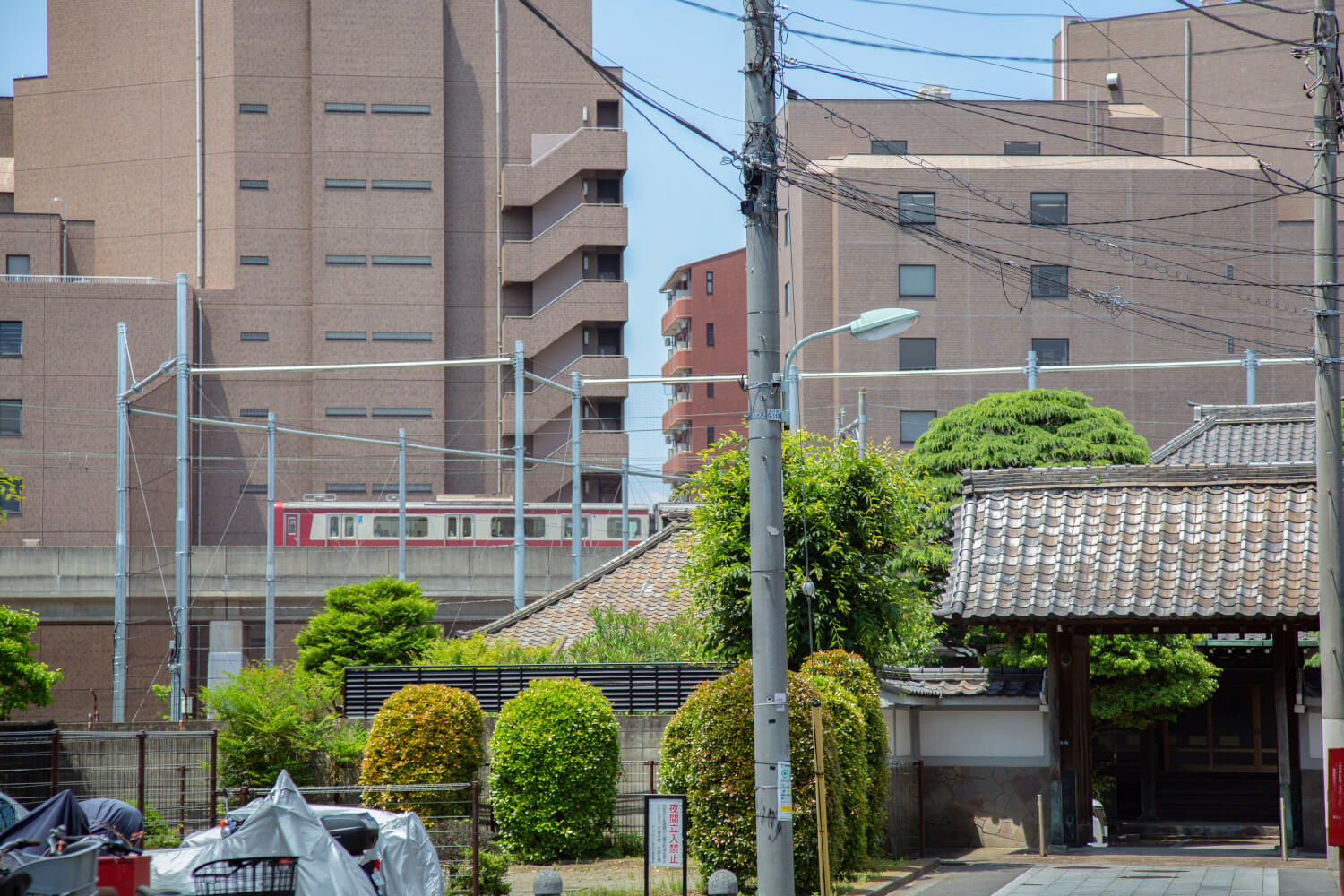 「あの動く大きな箱は何!? とても速いわ」　江戸期以前創建の寺が多い門前町。今はその背を京急本線が往来する。