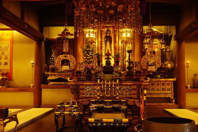 御本尊の阿弥陀如来像。本堂内の陰影が、厳かさと柔らかさを同時に感じさせる。