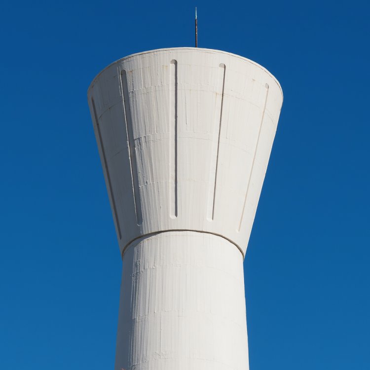 とっくり型の給水塔。青空に白い外壁が映える。