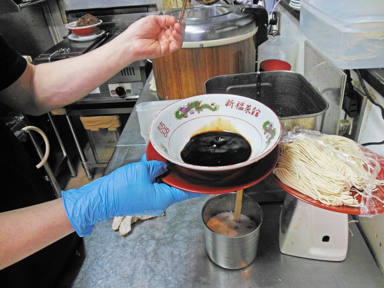 湯気で熱した熱々の器に、数種類のしょうゆをブレンドして作ったタレと鶏ガラ出汁のスープを注ぐ。