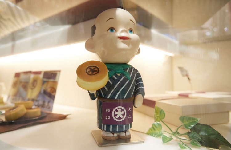 呉服屋の大店で奉公に励む丁稚どん、その名も「デッチ―くん」。おやつの大丸饅頭を手にゴキゲンだ