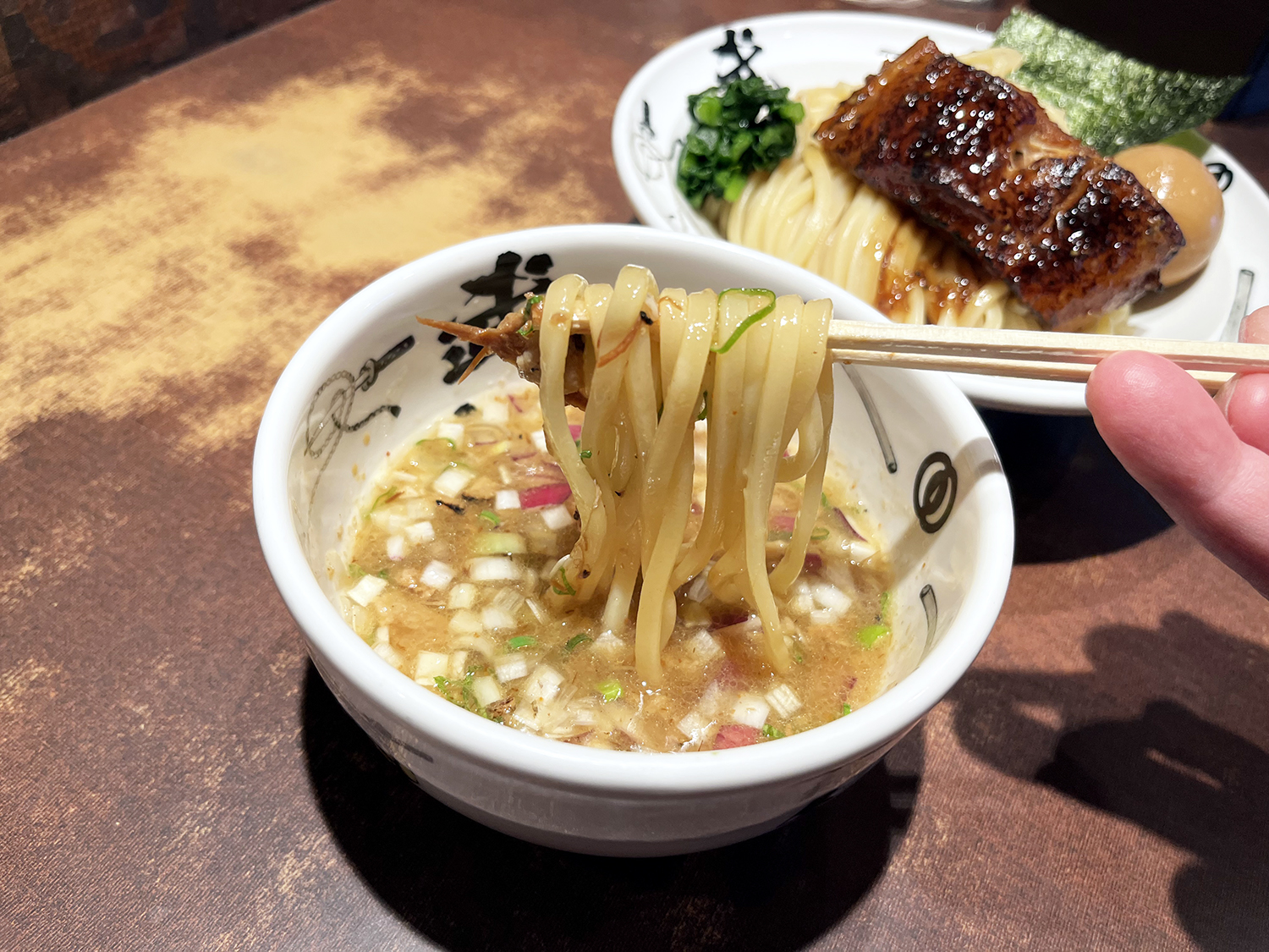 武仁肉と麺を一度にほおばると、スープに浮いたタマネギがいいアクセントになる。