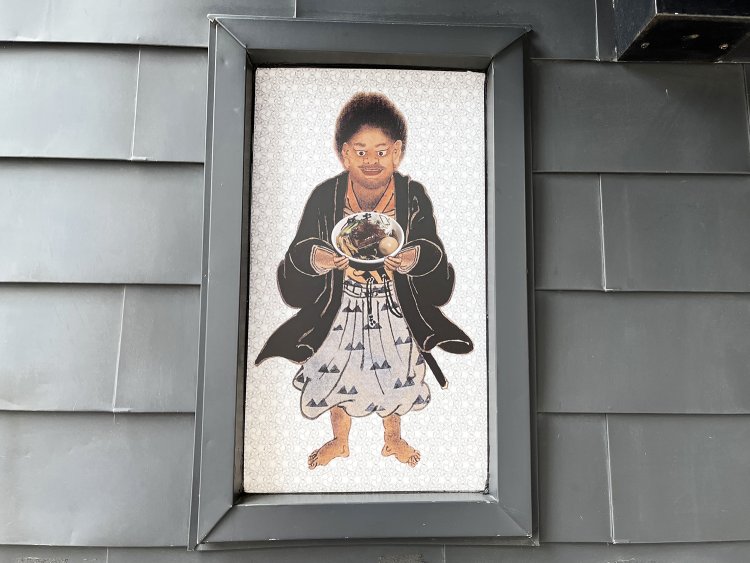 店頭の看板にて。コワモテの武蔵くんも武仁らーめんを目の前にすればニッコリ。