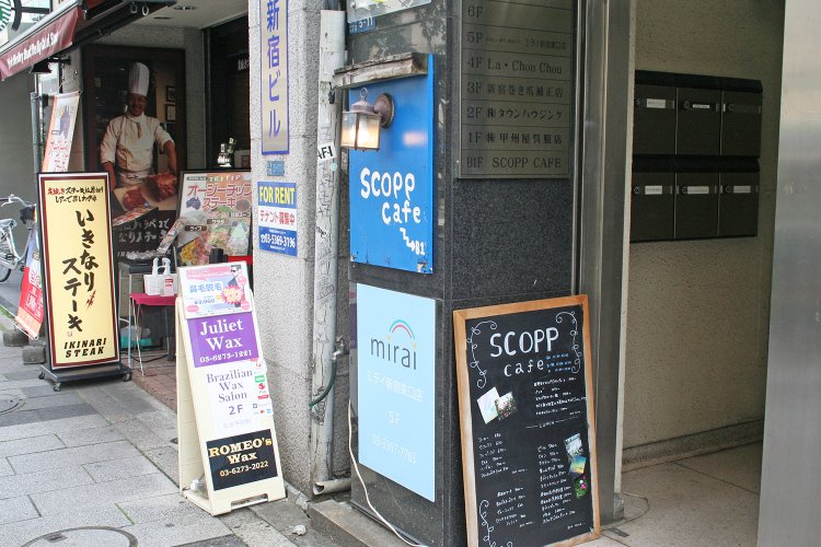 ビルの入り口にはかわいいランプがついたブルーの看板。新宿三丁目駅から向かうと黒板のメニューが目に入る。新宿御苑前駅の方から来る人は通り過ぎてしまわないように。