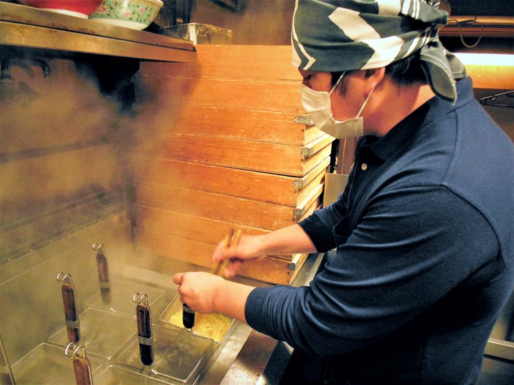 厨房スタッフの髙田直樹さん。多い時は昼時だけで200玉ほど麺を茹でるという。