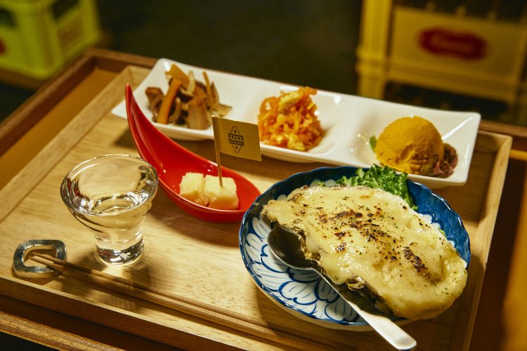 日替わり総菜三点盛り500円、牡蠣（かき）グラタン560円。チーズはPRキャンペーンで無料。