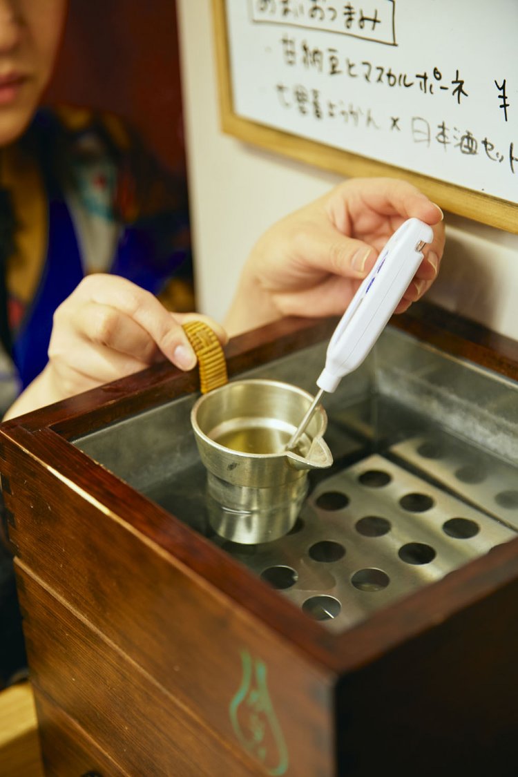 一推しという「不老泉」の燗をつけるスタッフの山沖亜矢さん。