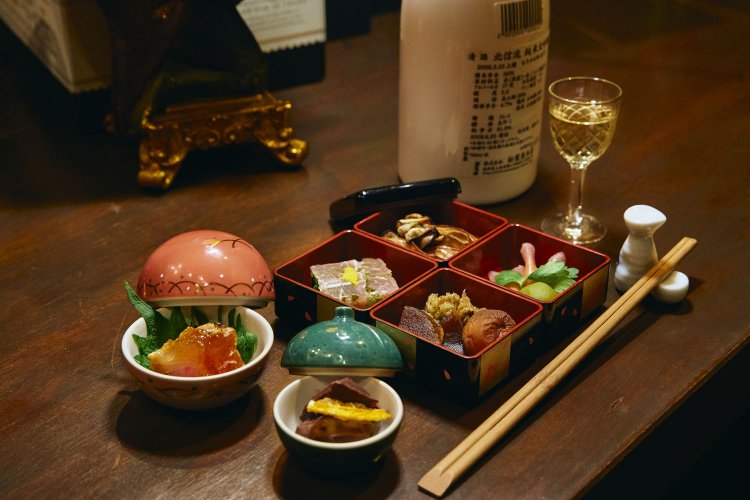 お通しは酒粕入りチョコレートや奈良漬けの燻製（くんせい）など500円。サービス料5％。