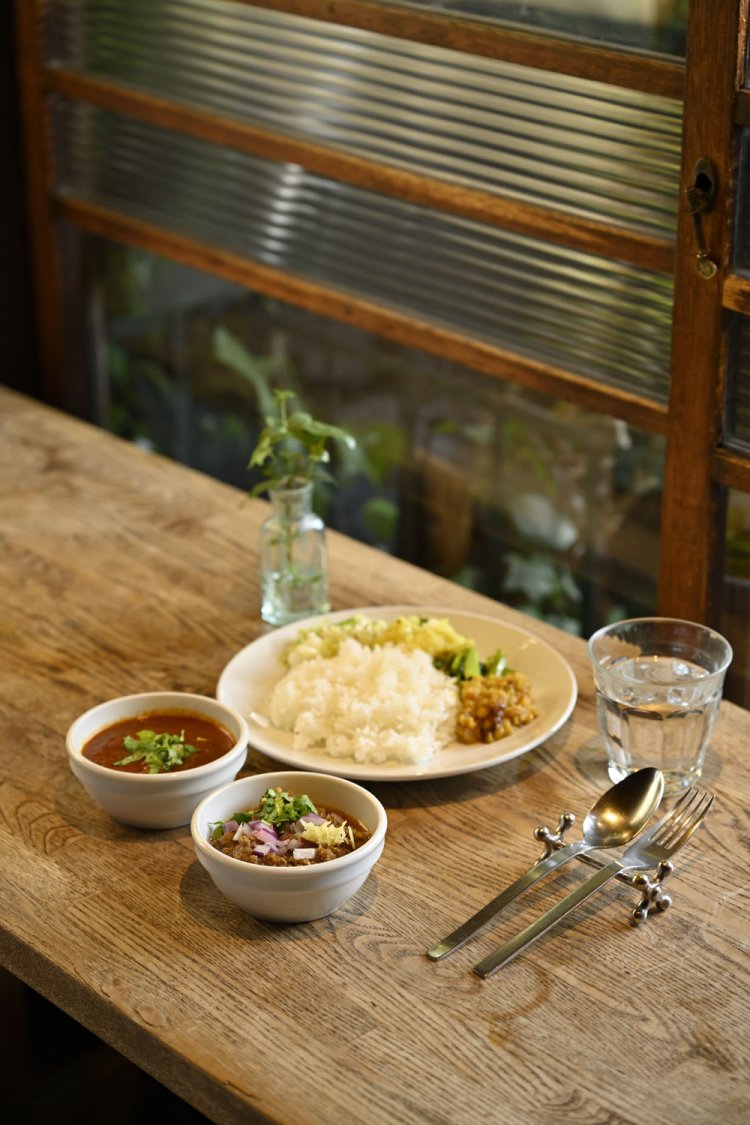 ランチのカレーは5～6種のラインナップから選べ、写真は2種盛り1450円。左から南インドがルーツのラッサム、花椒（ホアジャオ）をきかせたラムキーマ。デザート、飲み物付き。