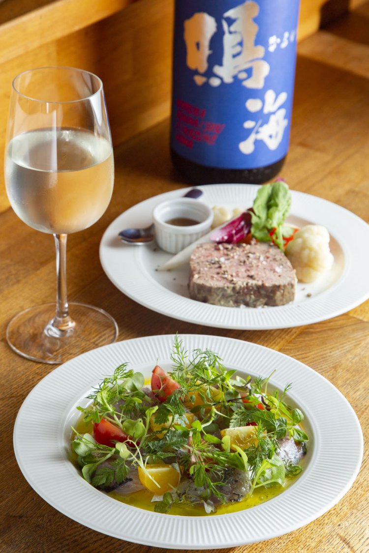 勝浦産のハーブを散らしたアジのカルパッチョ900円、自家製レバーのパテはちみつ添え850円。当日の「鳴海」は青の特別純米直詰めで1杯650円。