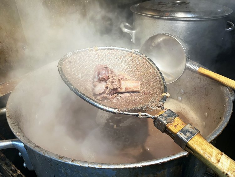 かき混ぜながらざるでガラをすくい肉の旨味だけを抽出する。