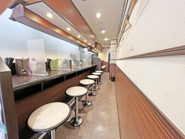 白と木目を基調にした店内はカウンターのみ。外にある券売機で食券を購入してから店内へ入ろう。