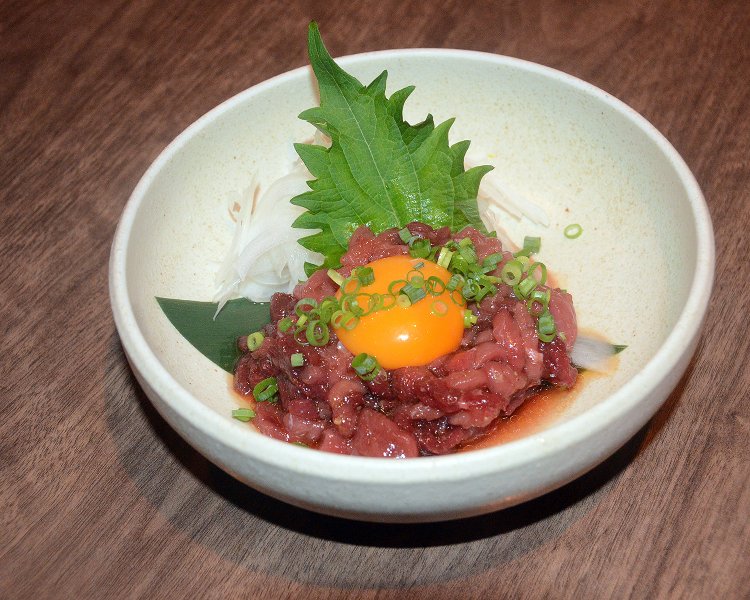 馬肉料理の定番、桜肉のユッケ715円。脂肪の少ない赤肉に濃厚な卵黄が相性抜群で食が進む。
