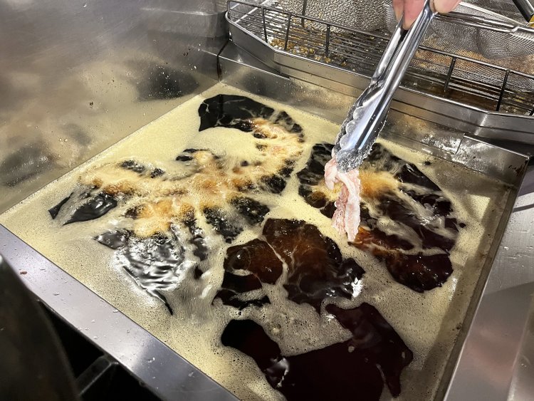 片栗粉をまぶした豚バラ肉をカラッと揚げる。