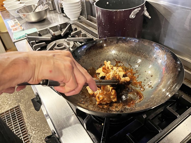 中華鍋で炒めながら揚げたバラ肉に甘辛い特製だれをからめる。