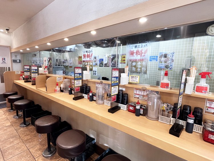 厨房前のカウンター席（8席）のほか、窓際にテーブルが3つ（10席）並ぶ。