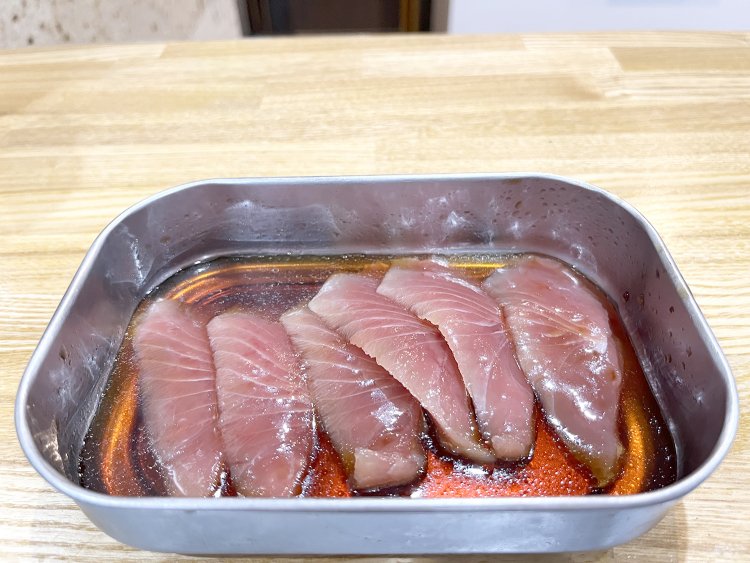 カツオの切り身をごまの風味が香る醤油ベースのつけだれに漬ける。