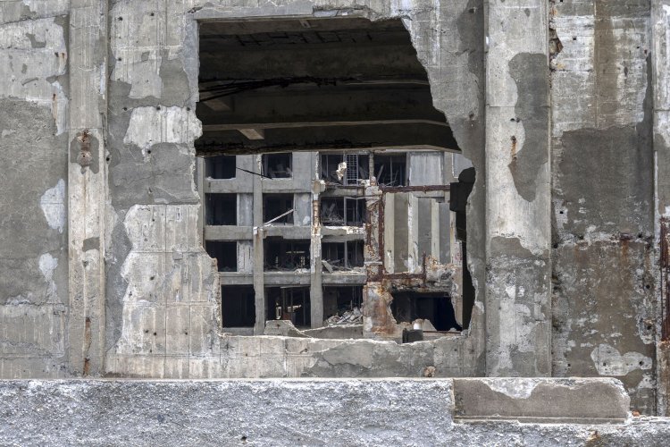 鉄材工場に開けられた、あるいは開口部であった空間から奥を覗く。30号棟がチラッと望めた。