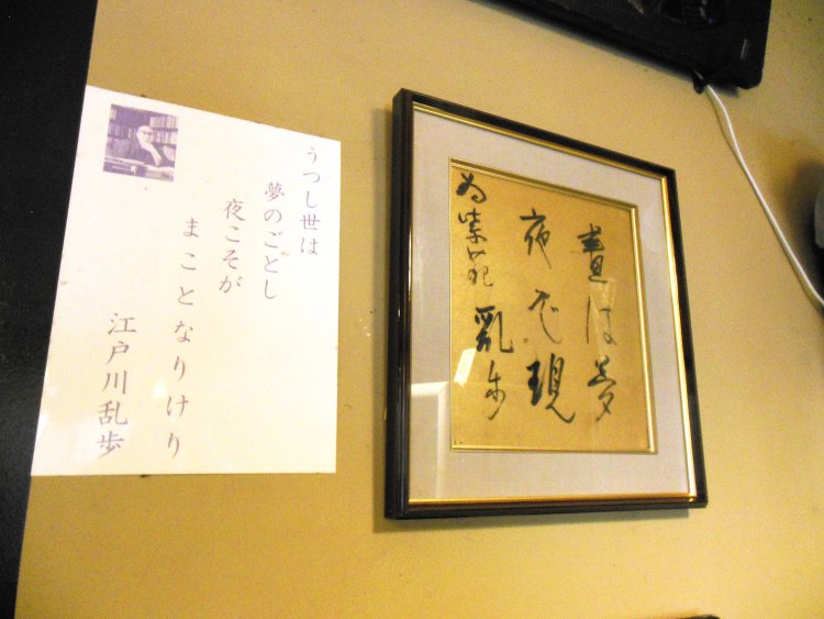 「晝（ひる）は夢　夜ぞ現（うつつ）」（うつし世は夢のごとし、夜こそがまことなりけり）と書かれた江戸川乱歩氏の直筆サイン。