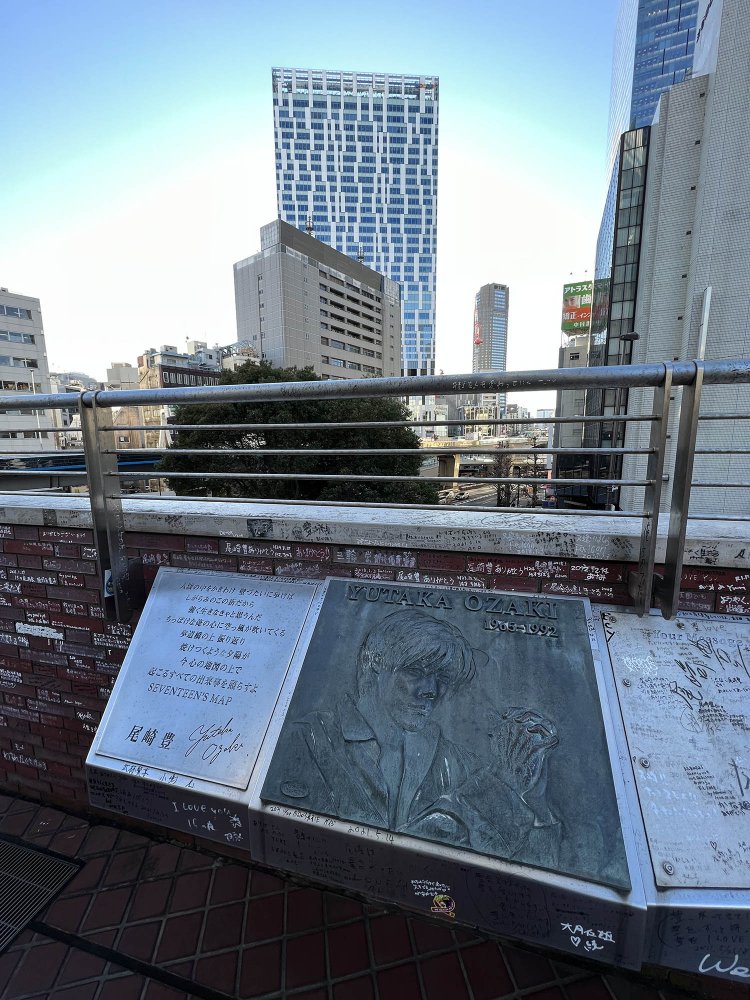 尾崎豊の歌碑。高校時代の彼は、いつもここに立って夕陽を眺めていたというのだが……いまは高層ビルの影に隠れて、夕陽を望むことはできない。