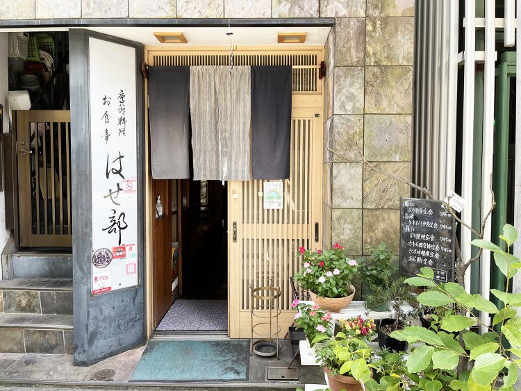 通りからでも目立つ看板。入り口を飾る鉢植えの植物が実家のようでアットホームな雰囲気。