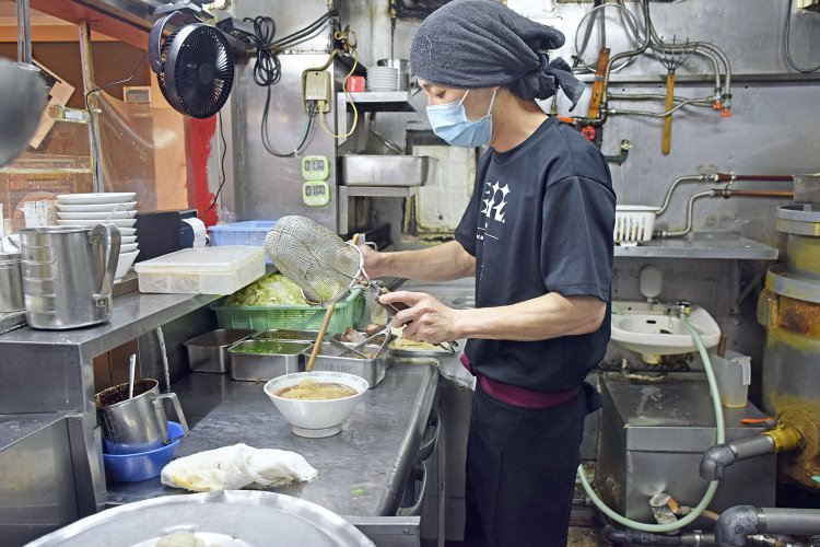 熊本ラーメンの特徴的な中太ストレート麺を、アルデンテの食感になるよう手早く茹でてスープの入った丼に投入。
