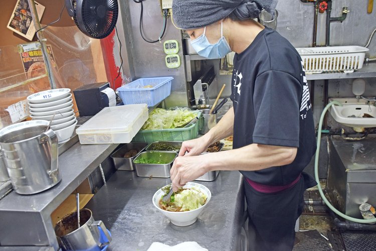 麺の上に、たっぷりのザク切りキャベツと茎ワカメなどをバランスよくトッピング。