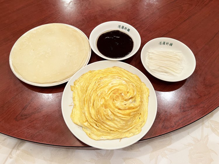 薄焼き卵をのせた野菜炒めとクレープのような薄餅、薬味のネギ、甜麺醤。