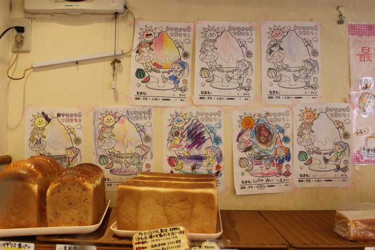 店に飾られた子どもたちの塗り絵。ベースの絵は津金さんの長女によるもの。