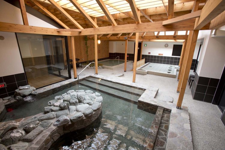 爽やかな風が吹く露天風呂。「らくの湯」は期間や季節ごとに替わり湯が楽しめる。