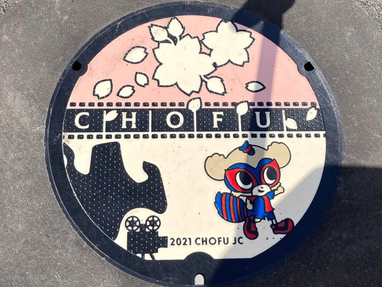 デザイン公募により制作された、桜と映画と東京ドロンパのマンホール。